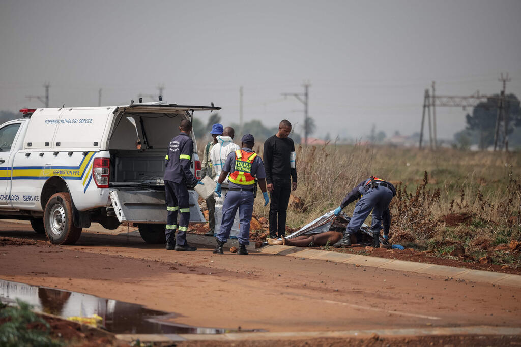 At the scene where a body was found two days ago. The number of bodies found has since risen to nine (Photo: EMMANUEL CROSET / AFP) דרום אפריקה חשד ל רוצח סדרתי 9 גופות של נשים נמצאו ליד יוהנסבורג 17 ספטמבר