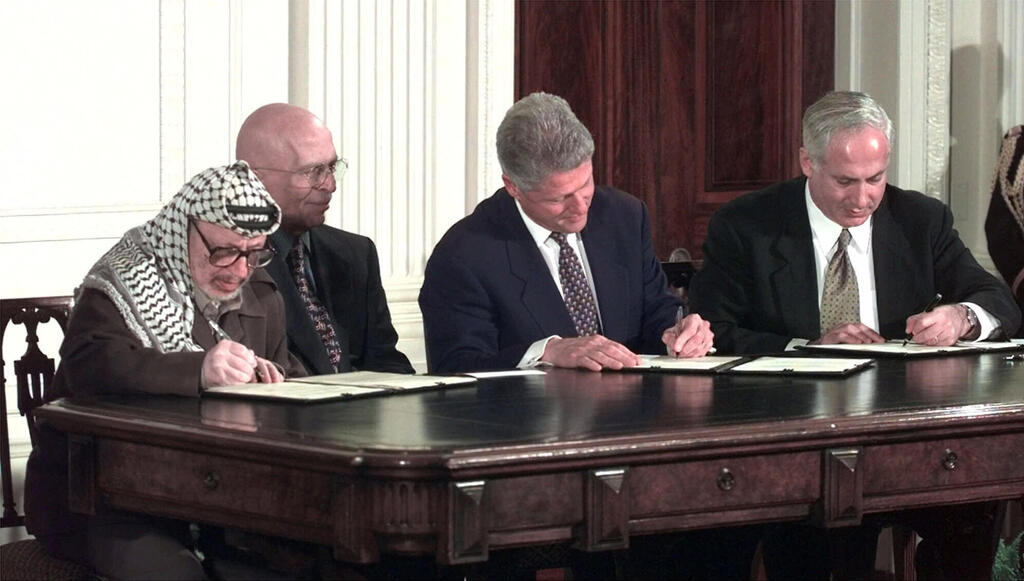 Netanyahu with Clinton and Arafat at the signing of the Wye River Memorandum in 1998 (Photo: AP/ Susan Walsh) ארכיון 1998 נשיא ארה"ב ביל קלינטון עם ראש ממשלת ישראל בנימין נתניהו וראש הרשות הפלסטינית יאסר ערפאת
