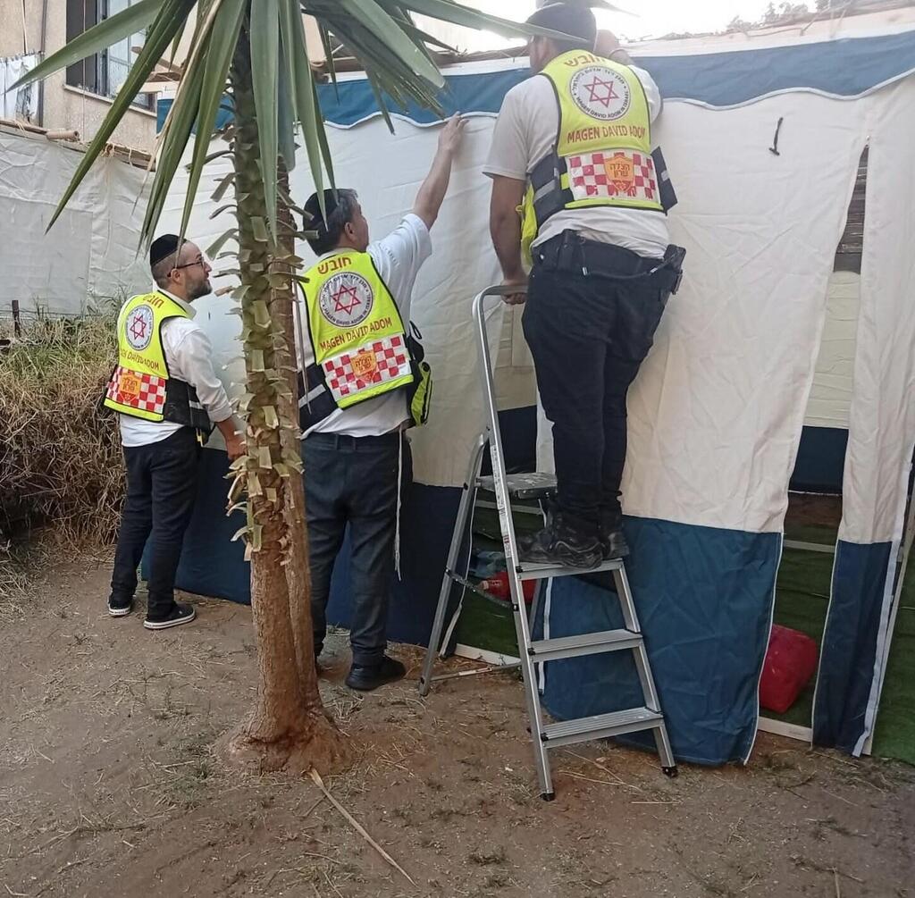 MDA medics finish building a sukkah after treating its owner, who was struck by a metal pole during construction (Photo: Magen David Adom) MDA medics finish building a sukkah after treating its owner, who was struck by a metal pole during construction