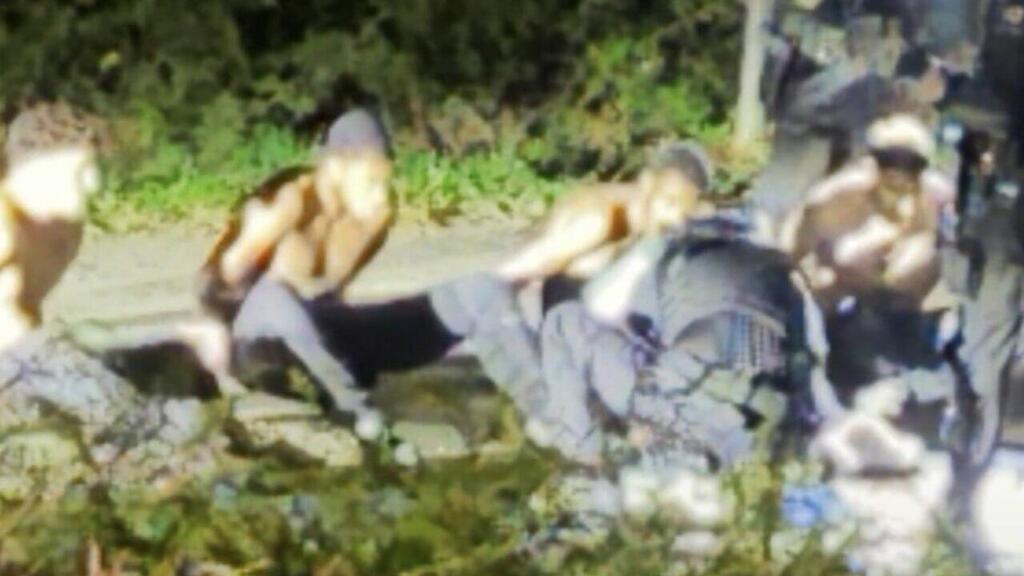Handcuffed, shirtless, on the side of the road. Documentation of the arret of the detainees (Photo: X) בריטניה חשד ל מזימת טרור ש סוכלה בסיס חיל האוויר פיירפורד תיעוד ה עצורים