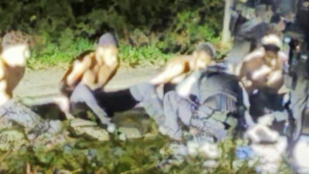 The five detainees on the sidewalk near the village of Walford, after being stripped, undergo a search (Photo: From X) בריטניה חשד ל מזימת טרור ש סוכלה בסיס חיל האוויר פיירפורד תיעוד ה עצורים