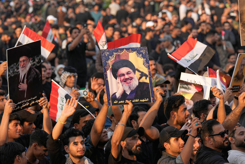 Supporters in Baghdad hold portraits of Hassan Nasrallah and Iraqi flags while marking two years since the Hezbollah leader’s death (Photo: AP Photo/Hadi Mizban) בגדד