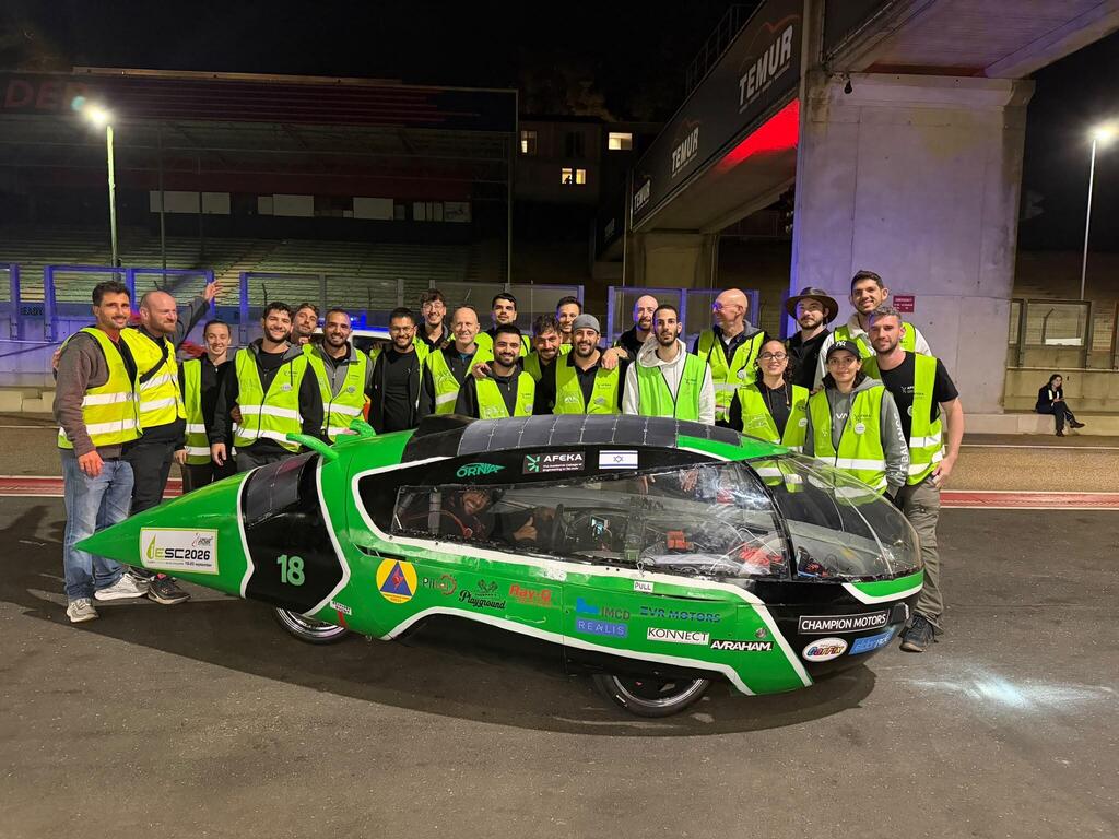 AFEKA Racing team members pose with their student-designed solar-powered car during the 24-hour iLumen European Solar Challenge in Belgium (Photo: Afeka College of Engineering) AFEKA Racing team members pose with an Israeli flag at the iLumen European Solar Challenge in Belgium