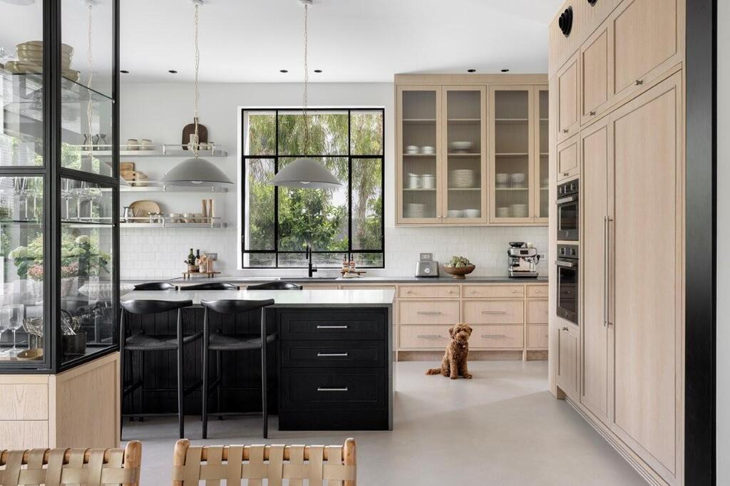Black accents contrast with natural oak cabinetry in the spacious family kitchen (Photo: Itay Benit) Black accents contrast with natural oak cabinetry in the spacious family kitchen