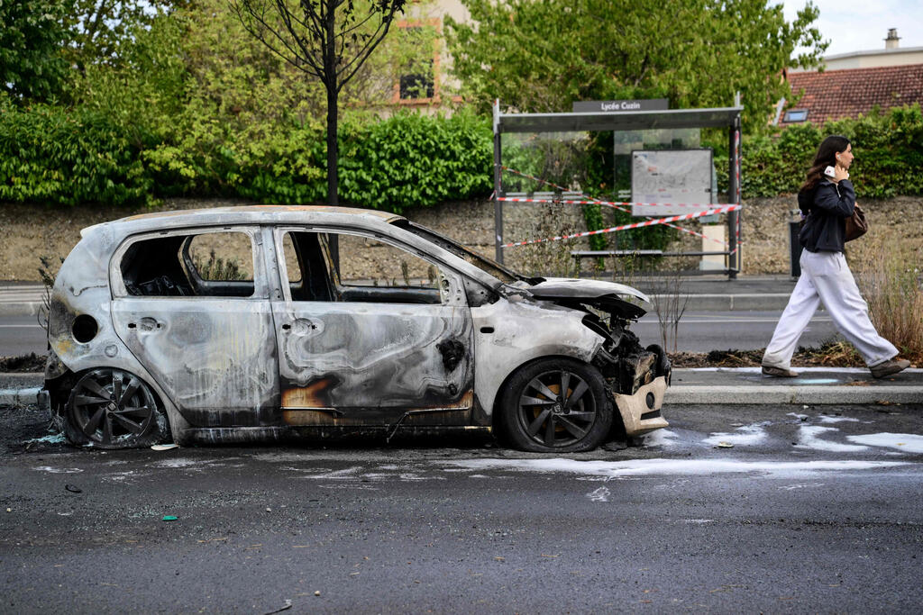 A vehicle burned during unrest in Lyon (Photo: OLIVIER CHASSIGNOLE / AFP) צרפת הפגנות תלמידים רכב שרוף ליון