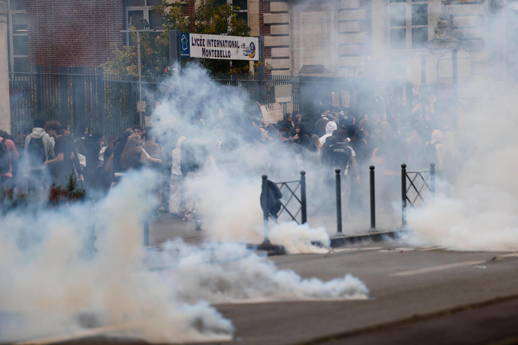 Tear gas at the entrance to a school in Lille on Wednesday morning (Photo: AP Photo/Jean-Francois Badias) צרפת הפגנות תלמידים שוטרים מפזרים גזר מדמיע אחרי ש תלמידים חסמו כניסה ל בית ספר ב ליל 30 ספטמבר