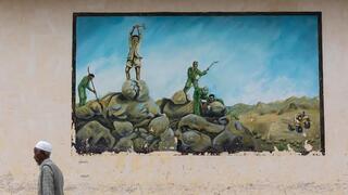 Eritrean man passing in front of a propaganda mural about the war with Ethiopia on Aug. 20, 2019 in Keren, Eritrea 