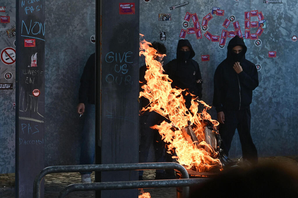 Masked rioters set fires in Liège. Authorities expect further vandalism (Photo: Nicolas TUCAT / AFP) בלגיה מהומות מפגינים ל שוטרים בהשראת מהומות ה תלמידים ב צרפת