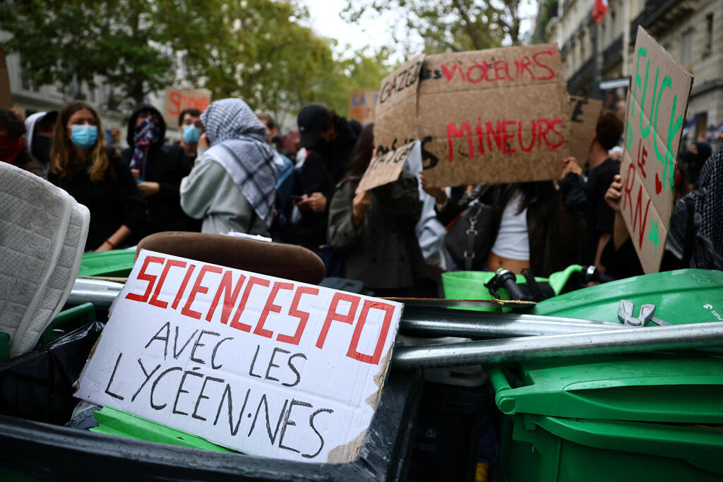 Trash cans and signs block the road outside Hélène Boucher High School in Paris. Palestinian keffiyehs were again spotted among the protesters Thursday (Photo: EUTERS/Sarah Meyssonnier) צרפת פריז מהומות תלמידים חוסמים כביש מול בית הספר התיכון הלן בושה