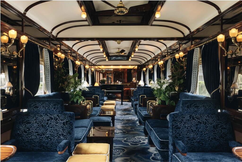 The historic bar car features blue velvet armchairs, warm lighting and a piano (Photo: belmond.com) אוריינט אקספרס, רכבת היוקרה של אירופה