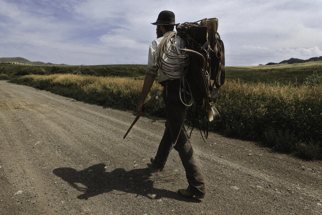 Heading out to saddle a horse, rifle in hand (Photo: Dan Lior) בדרך לאכוף את הסוס עם הרובה