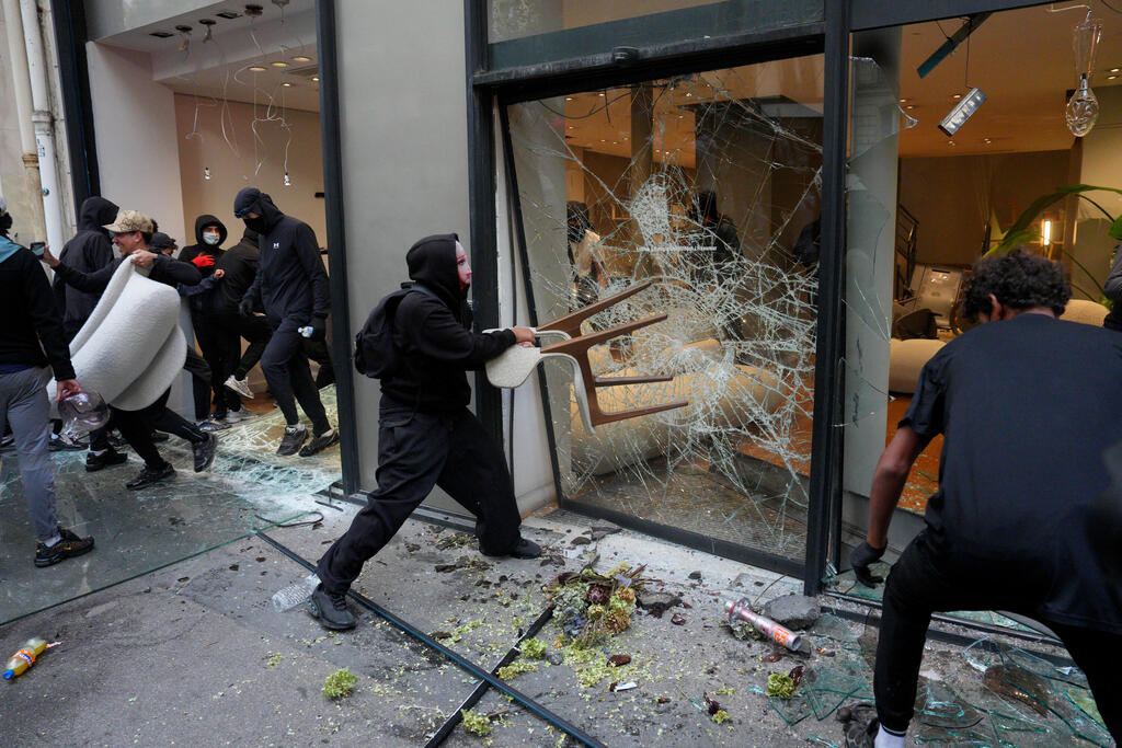 Rioters smash shop windows and flee with stolen merchandise in Paris on Saturday (Photo: Carl Court/Getty Images) מהומות צרפת פריז ביזה