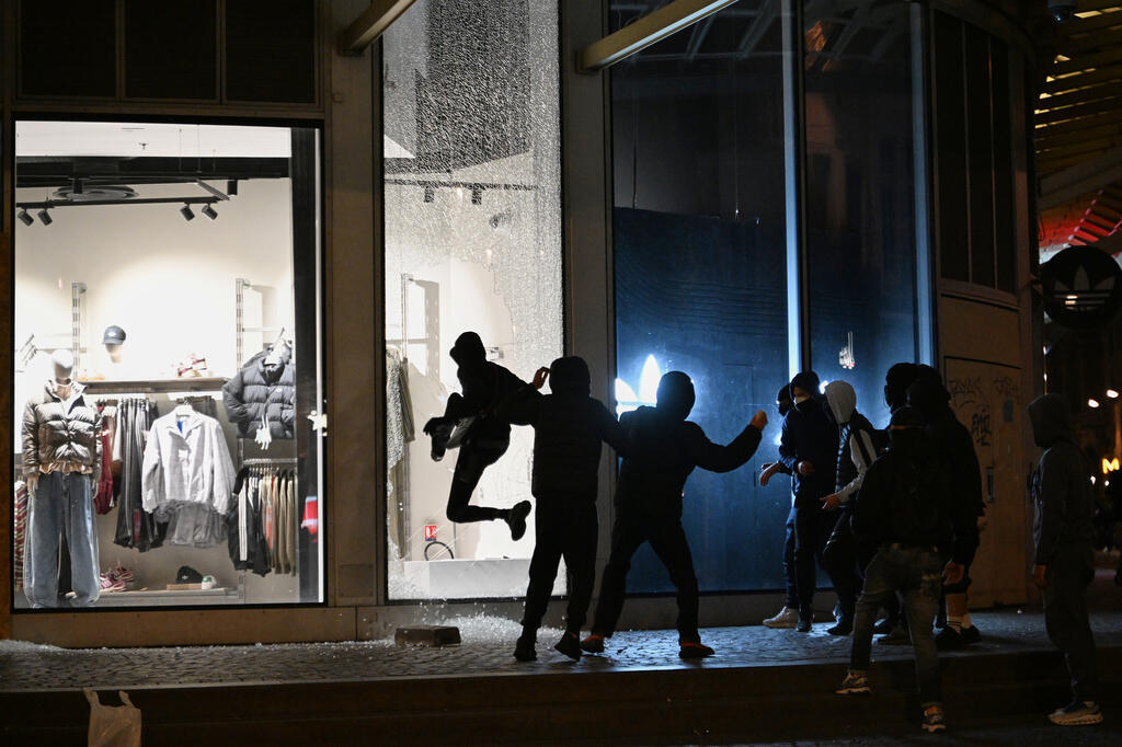 Young people loot a store in Paris during the riots (Photo: Emma Da Silva / AP) צעירים בוזזים חנות בפריז במהלך המהומות