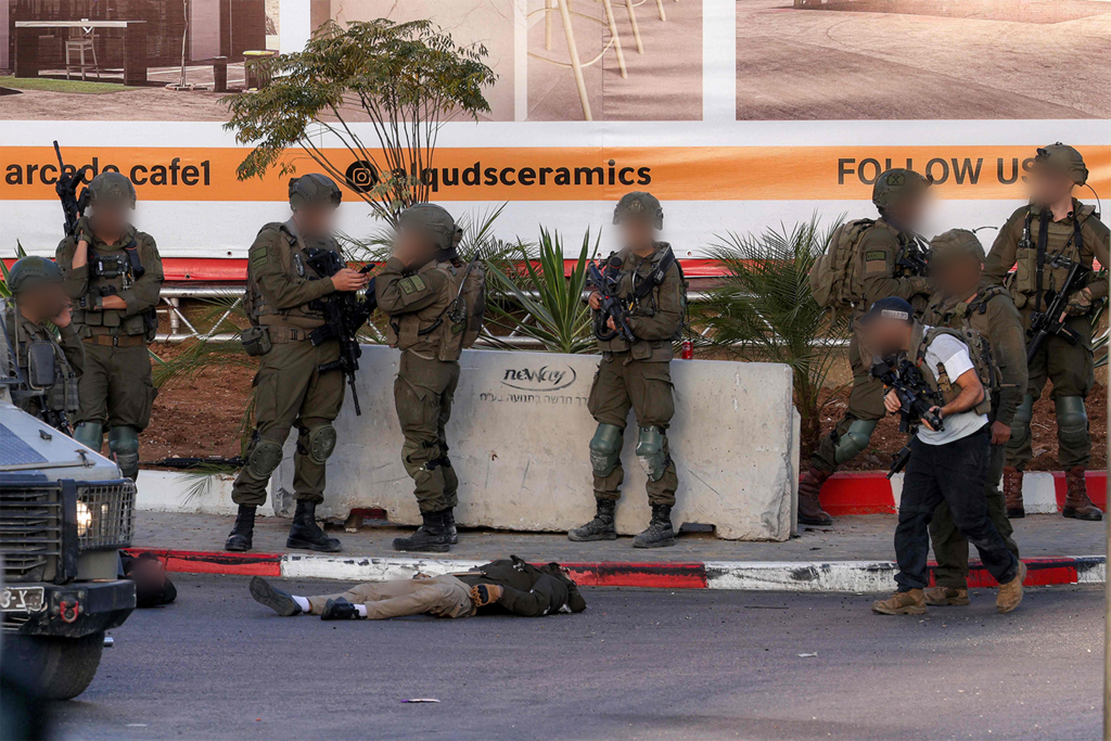IDF troops at the scene of the shooting attack, alongside the body of one of the terrorists (Photo: HAZEM BADER / AFP) זירת הפיגוע