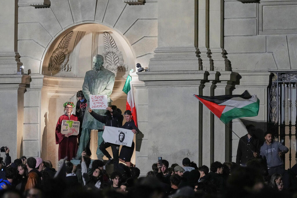 Demonstrators wave Palestinian flags during a protest in Milan (Photo: AP Photo/Antonio Calanni) מילאנו