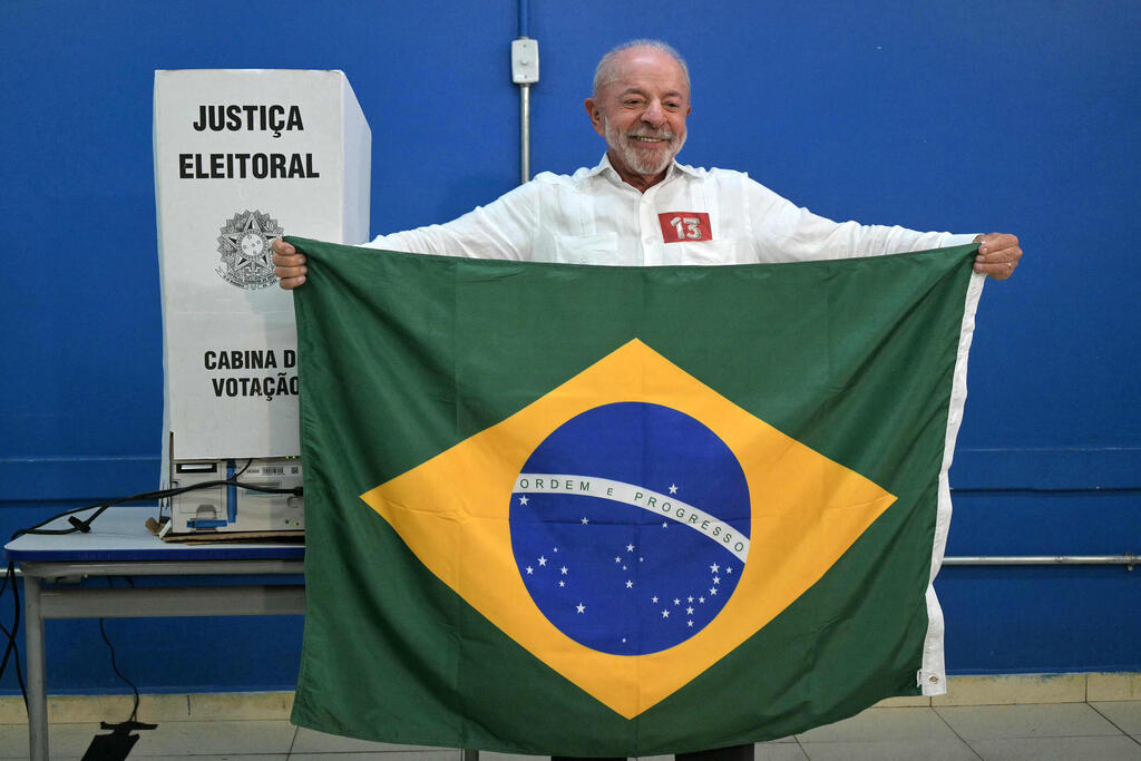 Lula waves the Brazilian flag at a polling station in São Paulo, accusing Bolsonaro of wanting to 'govern under the U.S. flag' (Photo: NELSON ALMEIDA / AFP) נשיא ברזיל לולה דה סילבה אחרי שהצביע ב בחירות בקלפי בסאו ברנרדו דו קמפו שבו סאו פאולו