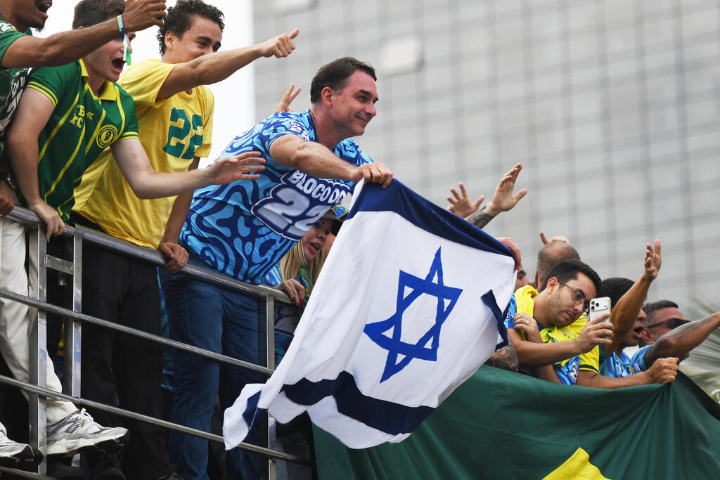 Bolsonaro waves an Israeli flag at a campaign rally Saturday; he has visited the West Bank and pledged to move Brazil's embassy to Jerusalem (Photo: AP Photo/Lucas Landau) ברזיל בחירות נשיאות עצרת סיום של תומכי פלאביו בולסונרו ריו דה ז'ניירו מניף דגל ישראל