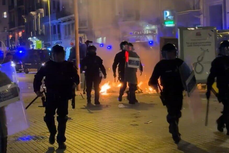 Police confront rioters as fires burn in the background during overnight unrest in Barcelona ספרד מהומות ברצלונה התפרעויות