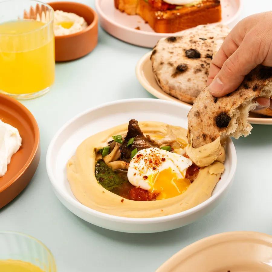 Fresh pita dipped into hummus topped with a poached egg and mushrooms at Safta's Table (Photo: Safta's Table) Fresh pita dipped into hummus topped with a poached egg and mushrooms at Safta's Table