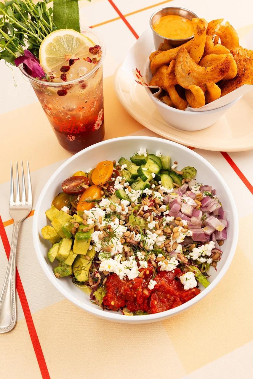 A fresh vegetable salad topped with cheese and seeds, served alongside seasoned potatoes at Safta's Table (Photo: Safta's Table) A fresh vegetable salad topped with cheese and seeds, served alongside seasoned potatoes at Safta's Table