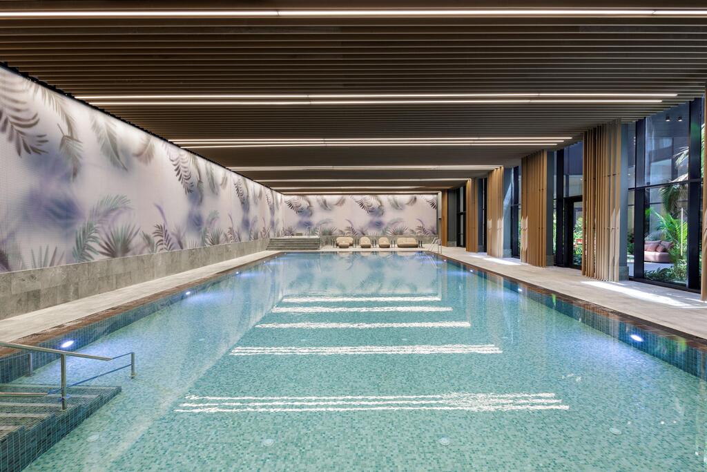 SEA ONE's indoor swimming pool overlooks a landscaped patio, providing residents with a year-round recreational facility (Photo: Eran Turgeman) SEA ONE's indoor swimming pool overlooks a landscaped patio, providing residents with a year-round recreational facility