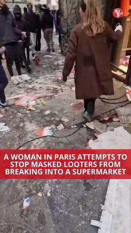 A woman in Paris attempts to stop masked looters from breaking into a supermarket