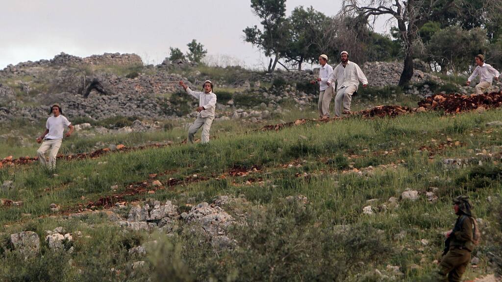 Members of the Hilltop Youth throwing stones at Palestinians in the West Bank (Photo: AFP) Members of the Hilltop Youth throwing stones at Palestinians in the West Bank