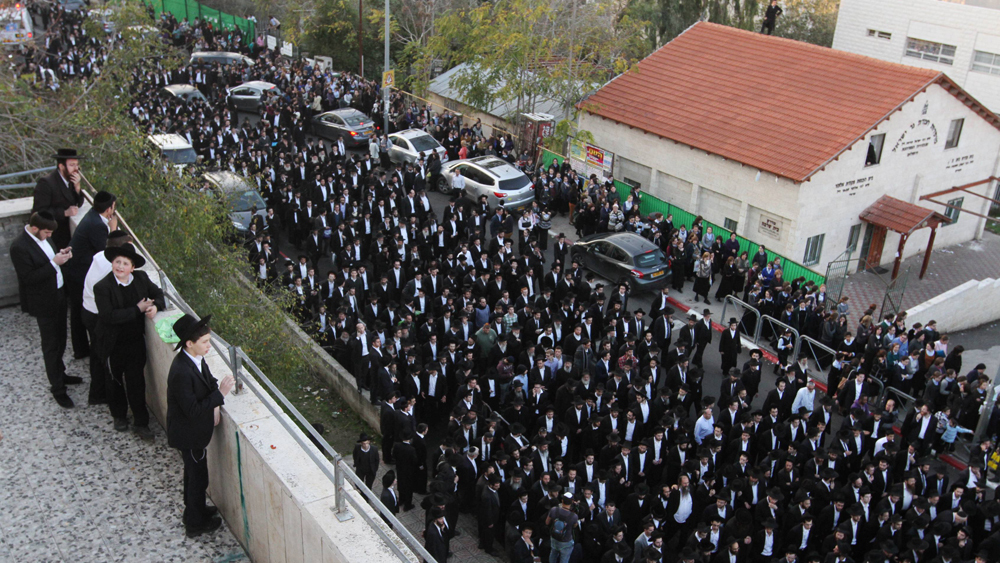 Thousands of Haredi men attend the Jerusalem funeral for a rabbi in Sunday, in violation of lockdown restrictions 