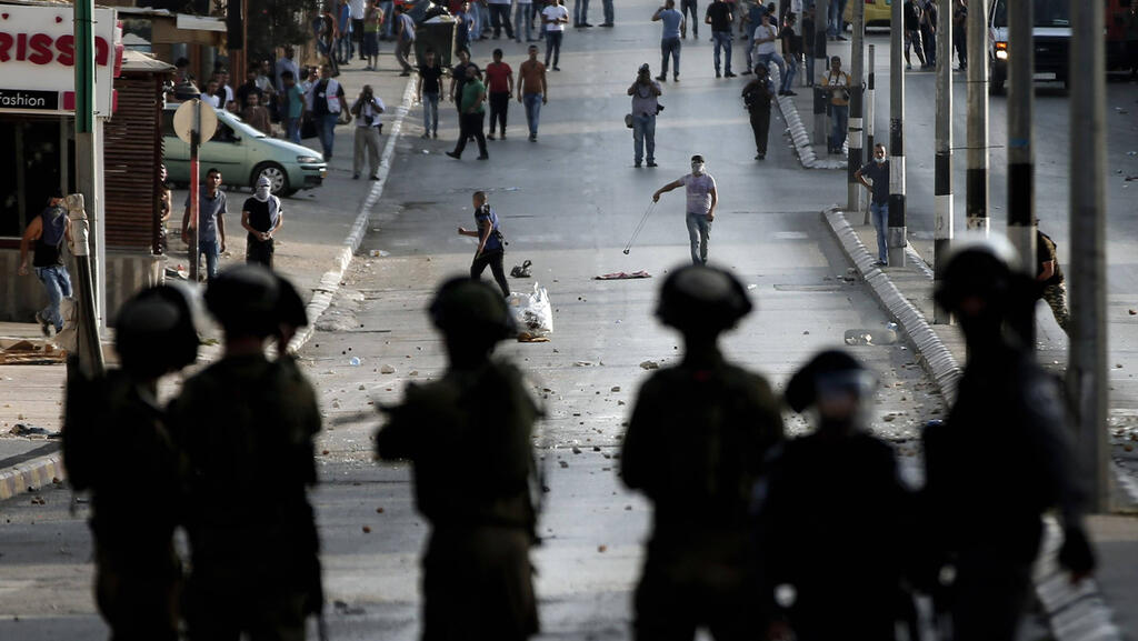 Israeli troops facing Palestinian rioters 