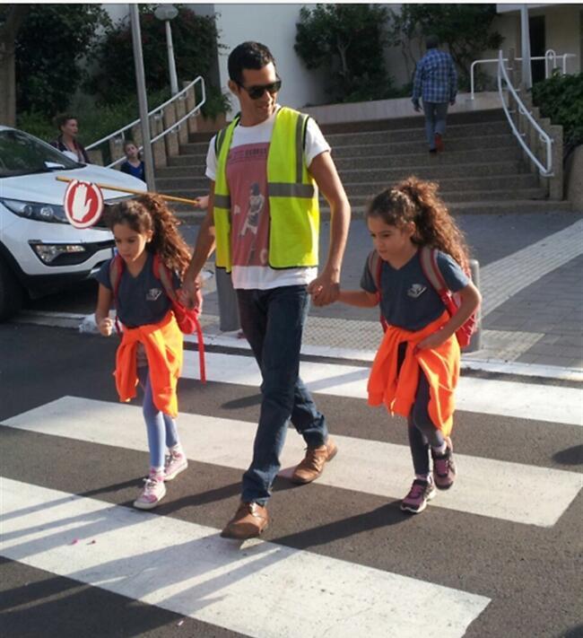 תחזיק לנו גם את היד. דן שפירא עוזר לילדות לחצות את הכביש (צילום מסך) תחזיק לנו גם את היד. דן שפירא עוזר לילדות לחצות את הכביש