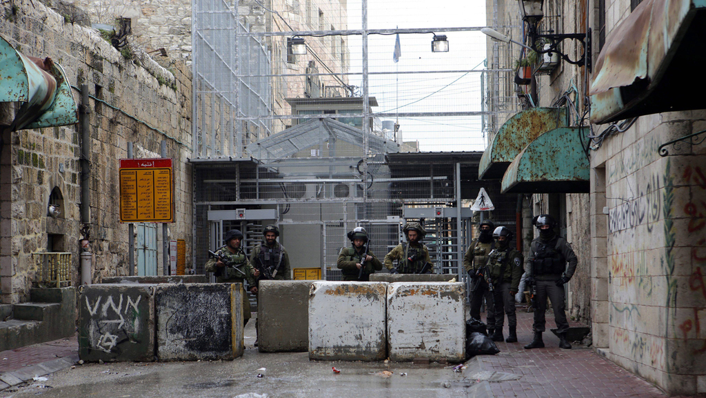 Soldiers guard the empty Al-Shuhada street in Hebron (Photo: EPA) Soldiers guard the empty Al-Shuhada street in Hebron