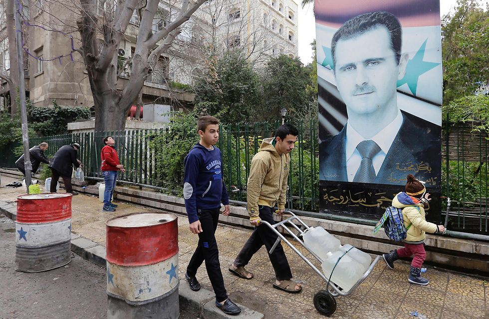 לוקחים בקבוקי מים גדולים בסוריה (צילום: AFP) לוקחים בקבוקי מים גדולים בסוריה