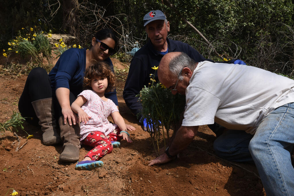 Family plants tree in Kibbutz Omer in northern Israel 