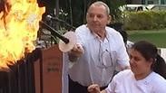 המאמן והמתנדב קובי וינר מדליק משואה עם בר בן זיקר 
