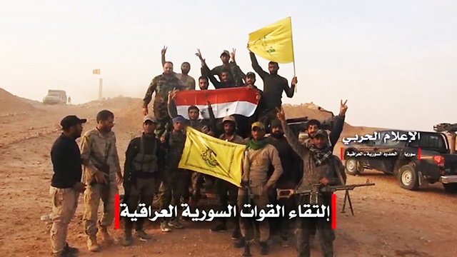 Iranian-backed militias in Syria holding Hezbollah flags 