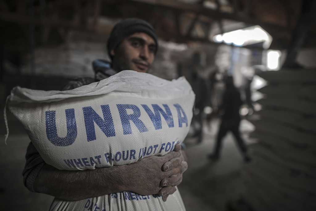 A Palestinian in Gaza receives a bag of flour from UNRWA depot 