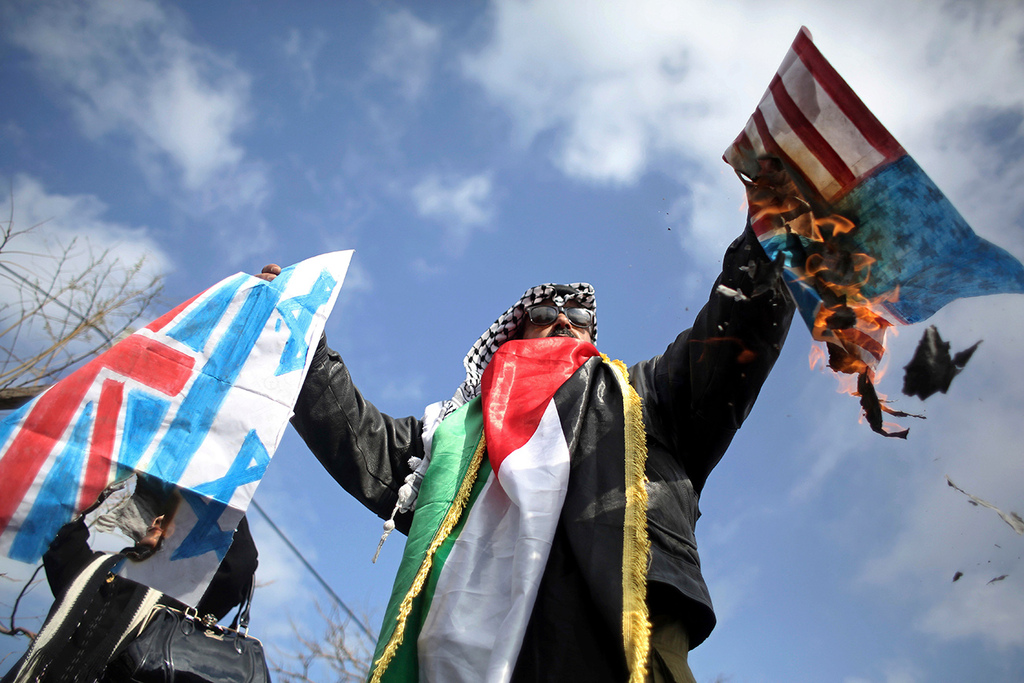 UNRWA worker burns U.S. and Israeli flags during strike against U.S. cutting aid funds to Palestinian refugees, January 29, 2018 