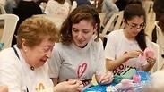 אישה מבוגרת ושתי צעירות עוסקות יחד במלאכת יד , מחייכות