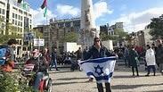 יהודי באמסטרדם שמפגין לבדו עם דגל ישראל ענק מול הפגנות הסתה של ה- BDS