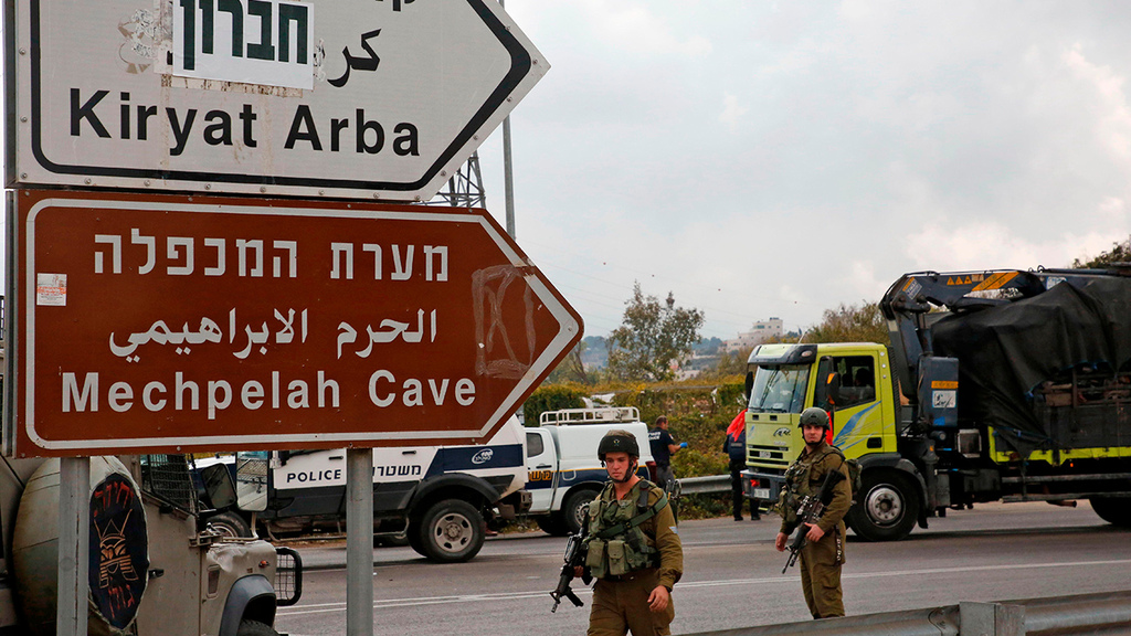 Troops at the entrance to Kiryat Arba and the Jewish settlements in Hebron (Photo: AFP) שלט חברון מערת המכפלה קריית ארבע