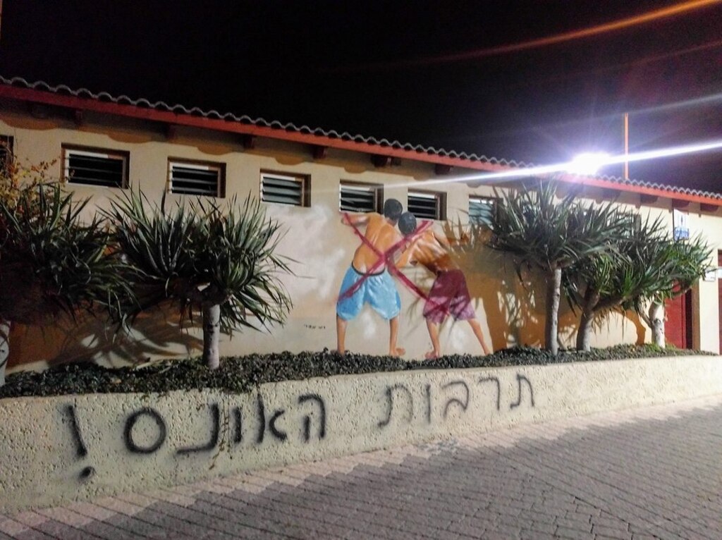 "תרבות האונס". הציור המיתולוגי של רמי מאירי בחוף מציצים, והתוספת של פעילות לוט"ם (צילום: לוט"ם תל אביב) פעילות לוט"ם השחיתו ציור קיר מיתולוגי של רמי מאירי בו מופיעים גברים המציצים לשירותי הנשים בחוף מציצים בתל אביב