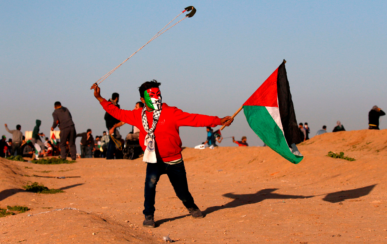 פלסטינים מפגינים מול גדר המערכת
