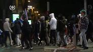 קבוצה קטנה של מוחאים מהעדה אתיופית מציתים פח אשפה