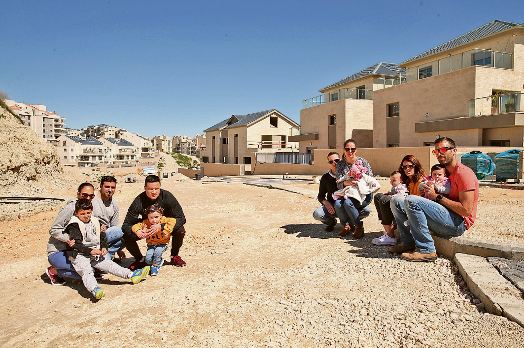 דיירים מפרויקט של עץ השקד ביקנעם על רקע הפרויקט והכביש שלא נסלל כבר חודשים ותמונות של הכביש על רקע