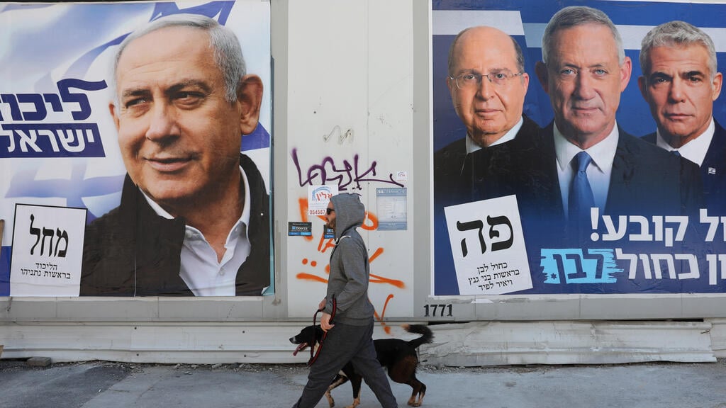 An Isrseli man walks past campaign posters for Benjamin Netanyahu and Benny Gantz ahead of the March 2020 elections (Photo: EPA) Israel Elections