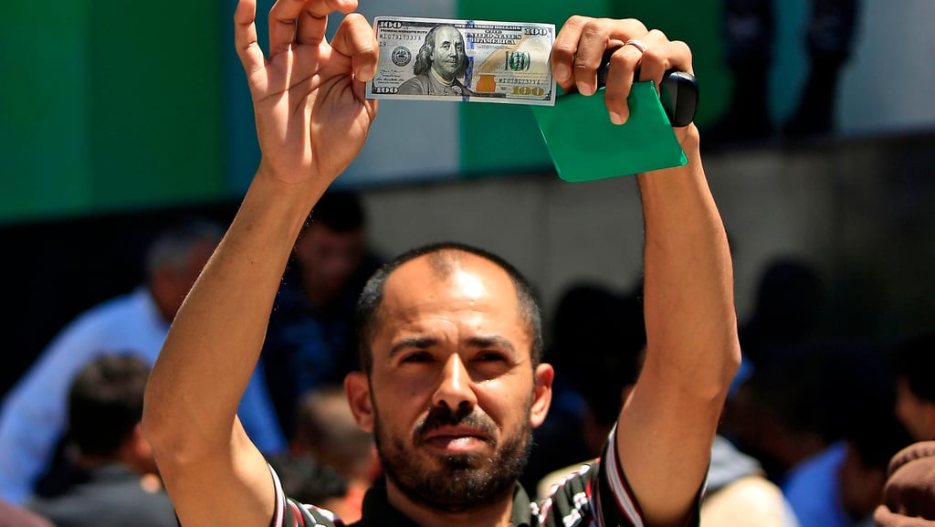 A Palestinian man showing the Qatari aid money he received in Gaza (Photo: AFP) חלוקת הכסף הקטארי בעזה