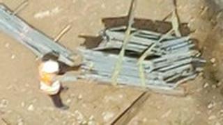 עבודה לא בטוחה עם מנוף מעל רכב חונה