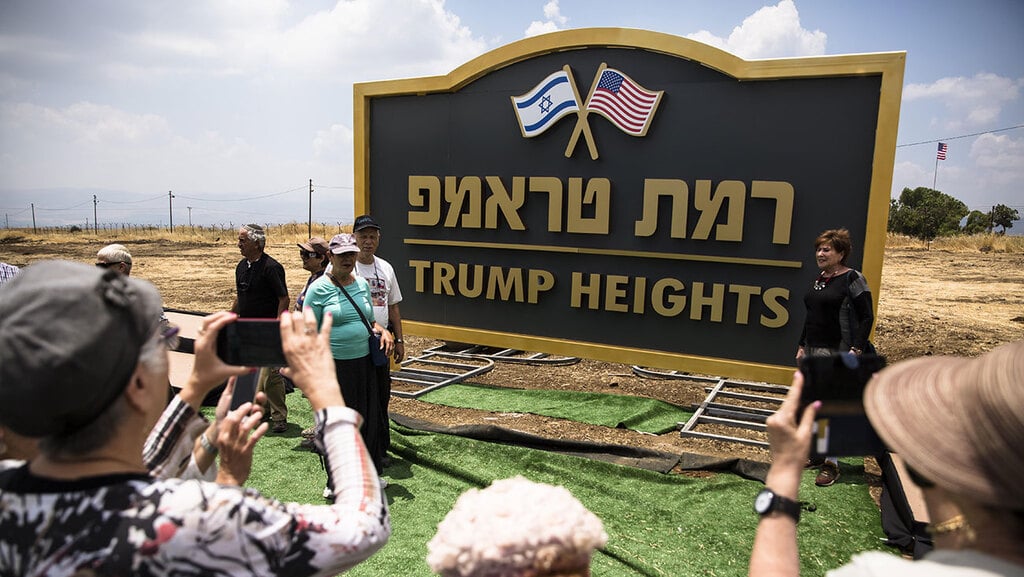 A ceremony to unveil a new Golan Heights community named after Donald Trump (Photo: Getty Images) אנשים מצטלמים ליד שלט יישוב רמת טראמפ