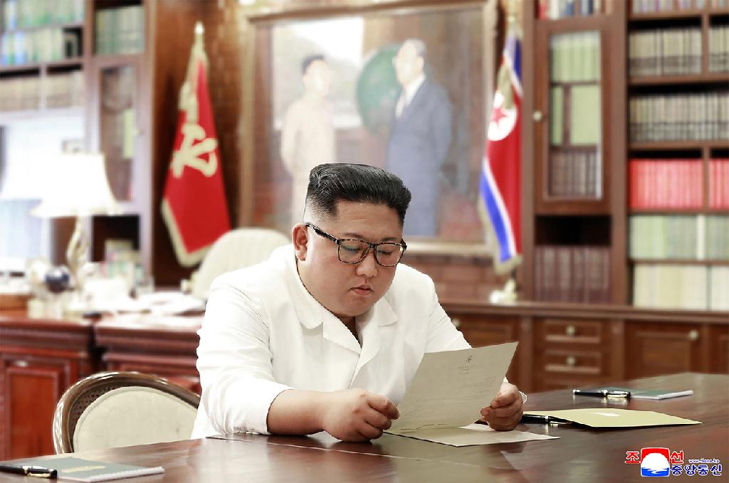 קים קורא מכתב שקיבל מטראמפ, 2019 (צילום: AFP PHOTO/KCNA VIA KNS) שליט צפון קוריאה קים ג'ונג און קורא מכתב שקיבל מ דונלד טראמפ ארה"ב