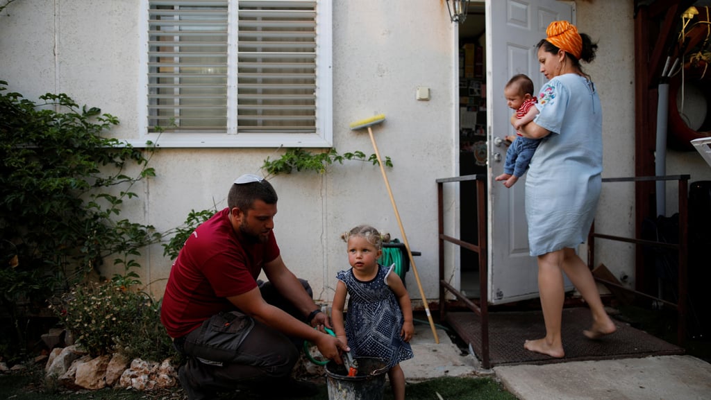 Settlers outside their prefabricated home in the settlement of Ofra (Photo: Reuters) Settlers outside their prefabricated home in the settlement of Ofra